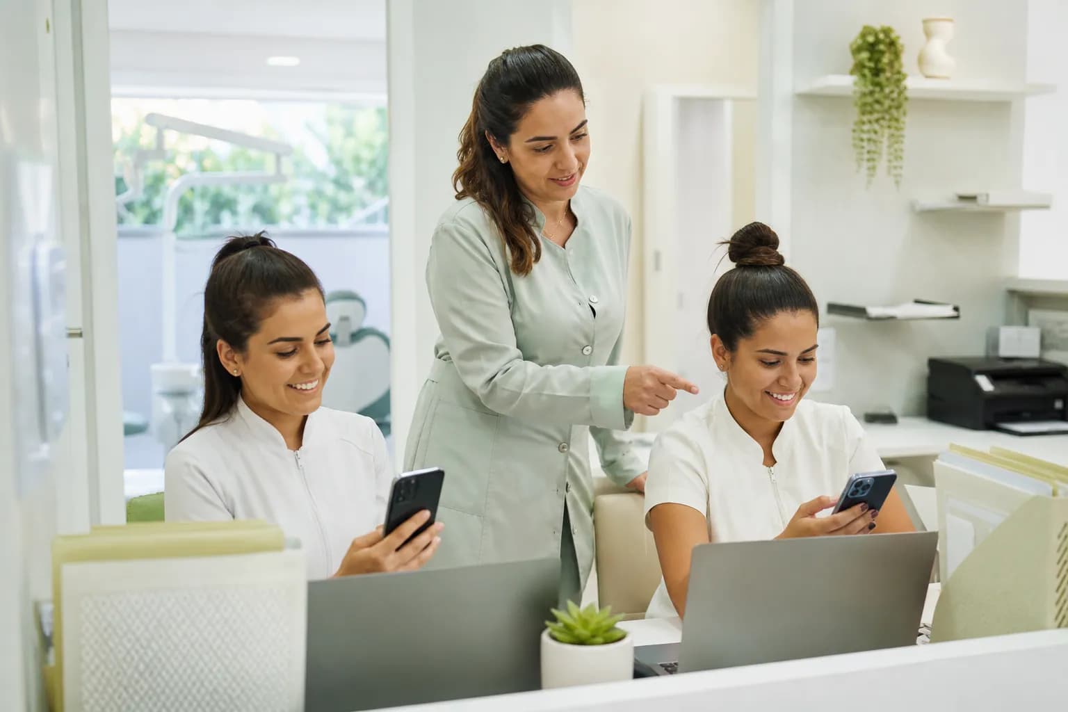 Supervisora de clínica odontológica distribui conversas entre duas atendentes com celulares na mesa